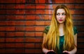 Blond woman and brick wall