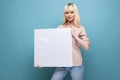 blond woman demonstrates a paper sheet with empty space for notes Royalty Free Stock Photo