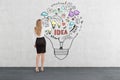 Blond woman drawing business idea sketch inside a light bulb Royalty Free Stock Photo