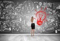 Blond woman drawing red light bulb Royalty Free Stock Photo
