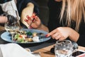 Blond woman eats delicious salmon salad with egg in a restaurant. small portion Royalty Free Stock Photo