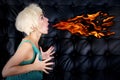 Blond woman in green dress spitting fire Royalty Free Stock Photo