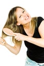 Blond woman having problem with brushing long straight tangled hair with hairbrush - hopeless situation Royalty Free Stock Photo