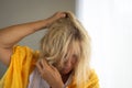 Blond woman in her 50s ruffling her hair. Concept of mental illness Royalty Free Stock Photo