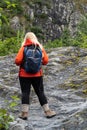 Blond woman hiker walks up a slippery rock trail covered in lichen Royalty Free Stock Photo