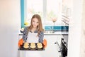 Blond woman holding a baking tray with freshly baked bread rolls. Royalty Free Stock Photo