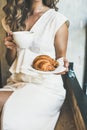 Blond woman holding fresh croissant and cup of cappuccino Royalty Free Stock Photo