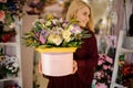 Blond woman holding hat box with flowers Royalty Free Stock Photo