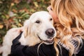 A blond woman hugging her retriever dog in the park Royalty Free Stock Photo