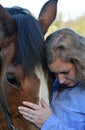 Blond woman hugs her  horse Royalty Free Stock Photo