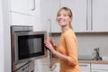 Blond woman with a microwave