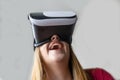 Blond woman playing and laughing, wearing virtual reality glasses. Excited, enjoying watching with tech vision fiction. Futuristic