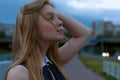 Blond woman portrait on street. Girl looking up at cloudy sky. a