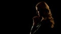 Blond woman praying in dark place, asking for forgiveness, sinner confession Royalty Free Stock Photo