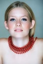 Blond woman with red beads