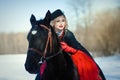 A girl in a long black dress with a dark horse Royalty Free Stock Photo