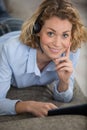blond woman relaxing in sofa calling with headset Royalty Free Stock Photo