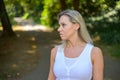 Blond woman standing in a shady country lane in summer Royalty Free Stock Photo