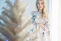 Blond woman stay near the window. christmas tree Royalty Free Stock Photo