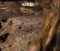 Blond woman with straw hat looking at the ruins and religious wall paintings and frescoes of the saints and the passion of Christ