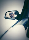 Blond woman in sunglasses looking in the car rear view mirror Royalty Free Stock Photo