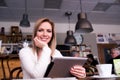 Blond woman with tablet in cafe drinking coffee Royalty Free Stock Photo