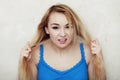 Blond woman teenage girl showing her damaged dry hair Royalty Free Stock Photo