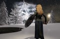 Blond woman Viking warrior with sword and shield in winter background