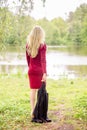 Blond woman wearing an office clothes walking into the park going to the lake. The picture reflects the return to natural life Royalty Free Stock Photo
