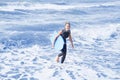 Blond woman in wetsuit and swimming board in the water