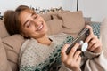 Blond young caucasian woman with perfect smile doing remote call, video conference, playing video games on her smart phone on Royalty Free Stock Photo