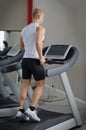 Blond young man running on treadmill Royalty Free Stock Photo