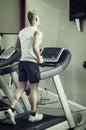 Blond young man running on treadmill Royalty Free Stock Photo