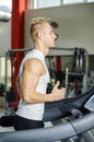 Blond young man running on treadmill Royalty Free Stock Photo