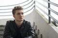 Blond young man sitting on stairs outside