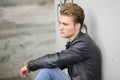 Blond young man sitting on stairs outside