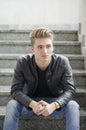 Blond young man sitting on stairs outside Royalty Free Stock Photo