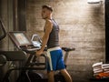 Blond young muscular man running on treadmill in gym Royalty Free Stock Photo