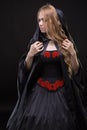 Blond young woman in black cloak Royalty Free Stock Photo