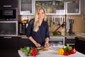 Blond young woman cooking salad in kitchen Royalty Free Stock Photo