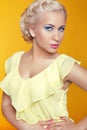 Blond young woman posing over yellow background Royalty Free Stock Photo