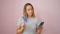 Blonde adult texting a serious payment message over pink isolated background