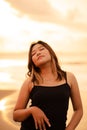 a blonde Asian woman with a beautiful face and black clothes enjoying the beauty of the beach and the waves in the morning Royalty Free Stock Photo