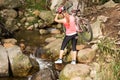 Blonde athlete carrying her mountain bike over stream Royalty Free Stock Photo