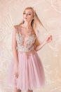 Blonde Attractive Woman, with Very Big Blue Eyes and Long Hair, with a Lace and Tulle Dress, Pulling Her Hair, on Pattern Pink Royalty Free Stock Photo