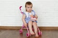 Baby girl test doll stroller. Funny cute baby girl riding in a toy doll stroller.