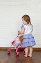 Baby girl test doll stroller. Funny cute baby girl riding in a toy doll stroller.