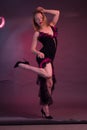 Blonde, in black Spanish Dressdress flamenco dancer in action, on a Burgundy background of the Studio Royalty Free Stock Photo