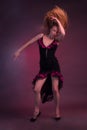 Blonde, in black Spanish Dressdress flamenco dancer in action, on a Burgundy background of the Studio Royalty Free Stock Photo
