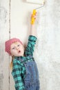 Blonde blue-eyed little girl doing repairs in the apartment